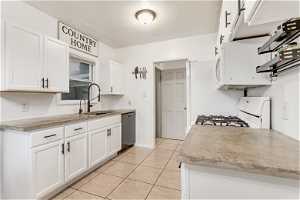 Kitchen featuring white cabinets, sink, white appliances, and light tile floors