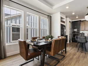 Dining room featuring hardwood / wood-style flooring and a raised ceiling