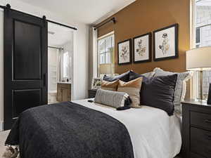 Bedroom with connected bathroom and a barn door