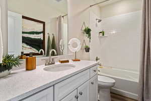 Full bathroom featuring shower / bathtub combination with curtain, vanity, and toilet