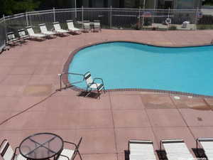 Community pool with a patio and fence