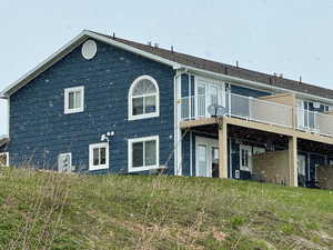 Rear view of property featuring deck on a snowy day