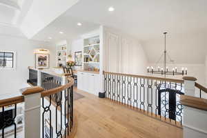 Hall with a chandelier and light wood-type flooring