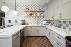Kitchen featuring sink, tasteful backsplash, kitchen peninsula, and lvp floors