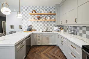 Kitchen featuring sink, tasteful backsplash, kitchen peninsula, and lvp floors