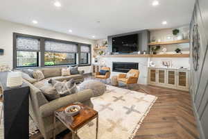 Living room featuring  lvp flooring, a textured ceiling, and brick wall