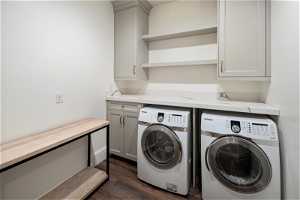 Laundry room with LVP, cabinets, and washer and clothes dryer