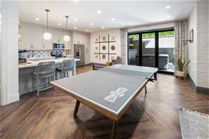 Game room featuring lvp floors and brick wall