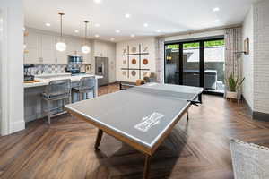 Game room featuring lvp floors and brick wall