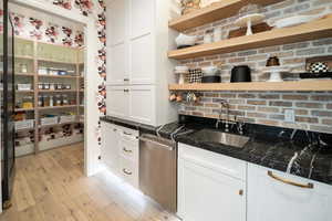 Kitchen featuring white cabinets, sink, and light wood-type flooring