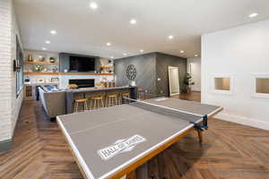 Game room featuring lvp floors and brick wall