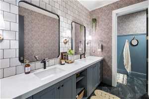 Bathroom with tile walls, dual bowl vanity, and tile flooring