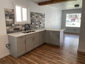 Kitchen featuring a wealth of natural light, gray cabinetry, dark hardwood / wood-style flooring, and sink