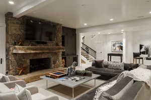 Living room featuring stairway, a fireplace, and recessed lighting