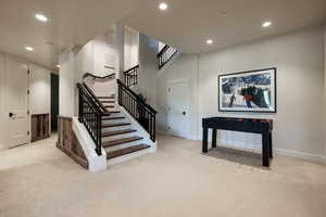 Stairs with recessed lighting and carpet