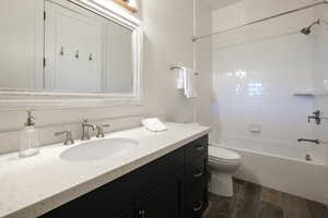 Full bath featuring wood finished floors, bathing tub / shower combination, and vanity