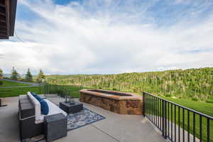 Patio / terrace featuring a wooded view and a yard