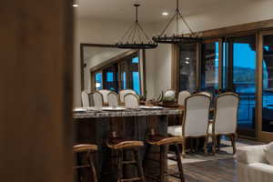 Dining area with a chandelier, dark wood-style flooring, and recessed lighting