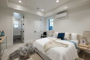 Bedroom featuring a wall mounted air conditioner, carpet, recessed lighting, and ensuite bathroom