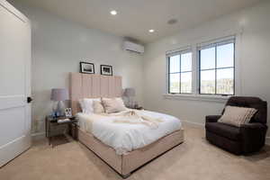 Bedroom with an AC wall unit, carpet, and recessed lighting