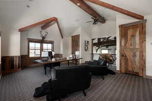 Carpeted living room featuring a wainscoted wall and wooden walls