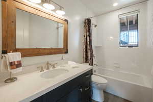 Full bathroom with vanity, shower / bath combination with curtain, and wood finished floors