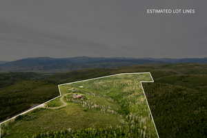 Aerial overview of property's location featuring a mountainous background and property boundaries highlighted