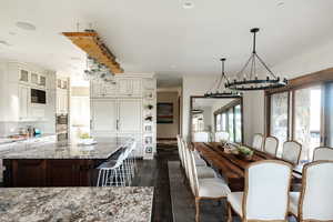 Dining area with a chandelier, dark wood-type flooring, and recessed lighting