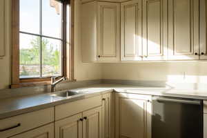 Kitchen with dishwasher, light countertops, and white cabinetry