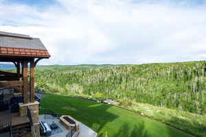 View of grassy yard with a view of trees