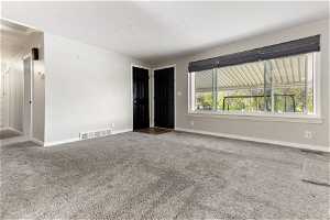 Empty room featuring a wealth of natural light and carpet flooring