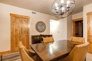 Dining room with an inviting chandelier and light tile floors