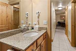 Bathroom featuring tile flooring and vanity with extensive cabinet space