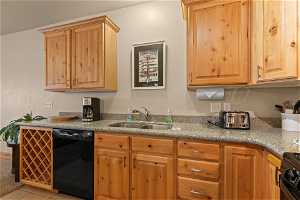 Kitchen featuring range with electric stovetop, dishwasher, light tile floors, and sink