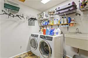 Clothes washing area featuring tile flooring and washer and dryer