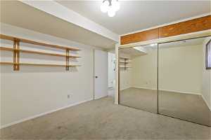 Unfurnished bedroom featuring a closet, a textured ceiling, and carpet flooring