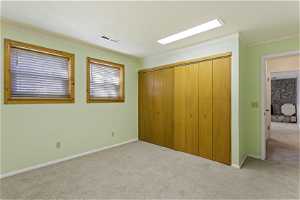 Unfurnished bedroom featuring a closet, carpet flooring, and crown molding