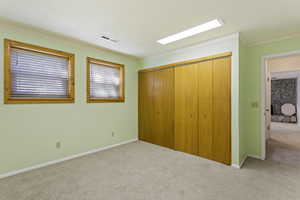 Unfurnished bedroom featuring a closet, carpet flooring, and crown molding