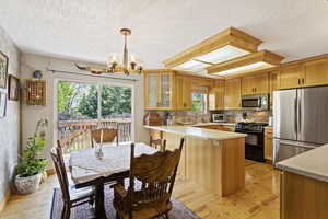 Kitchen featuring a notable chandelier, appliances with stainless steel finishes, light hardwood / wood-style floors, and plenty of natural light