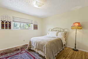 Bedroom featuring wood-type flooring and a textured ceiling