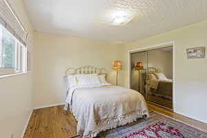 Bedroom with a closet, hardwood / wood-style flooring, and a textured ceiling