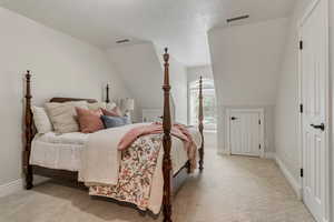 Bedroom with carpet flooring and lofted ceiling