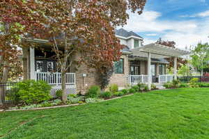 View of front of property featuring a porch, a front yard, and a pergola