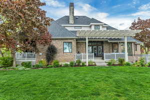 View of front facade with a pergola and a front yard