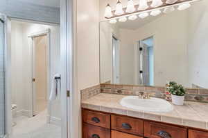 Bathroom with vanity, tile floors, and toilet