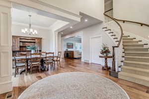 Dining room featuring ornamental molding, a notable chandelier, and hardwood / wood-style flooring