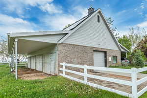 View of property exterior featuring a carport and a lawn