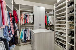 Spacious closet featuring light colored carpet