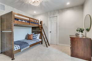 Carpeted bedroom featuring an inviting chandelier