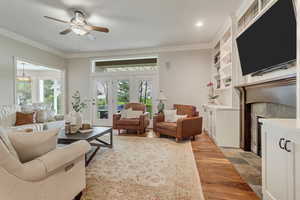 Living room featuring a wealth of natural light, ceiling fan, light hardwood / wood-style floors, and crown molding